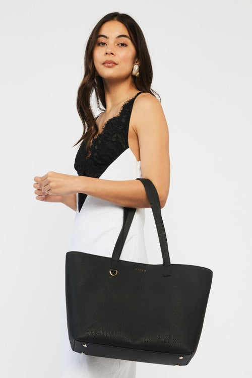 model wears a black tote bag