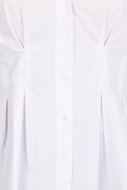 Close-up of a white long-sleeve button-up shirt with a vertical button placket and gathered side seams.