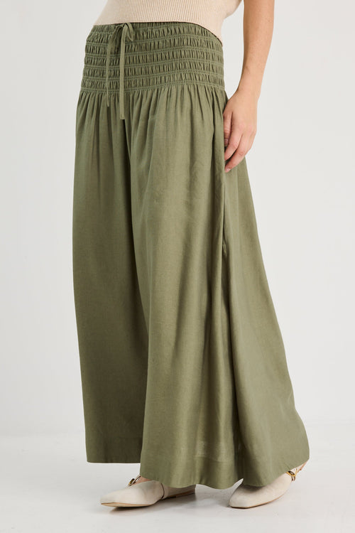 Person wearing a green skirt on a white background