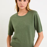 Model wearing a khaki short sleeve crew neck knit tee made from a soft cotton-cashmere blend.