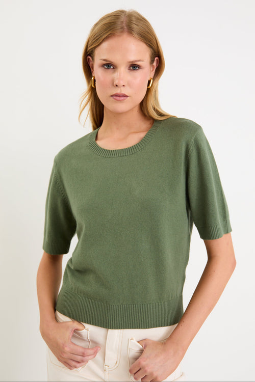 Model wearing a khaki short sleeve crew neck knit tee made from a soft cotton-cashmere blend.