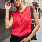 Model wears a cherry red knit vest with gold buttons. 