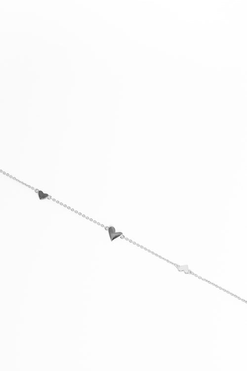 Silver bracelet with heart and triangle charms on a white background