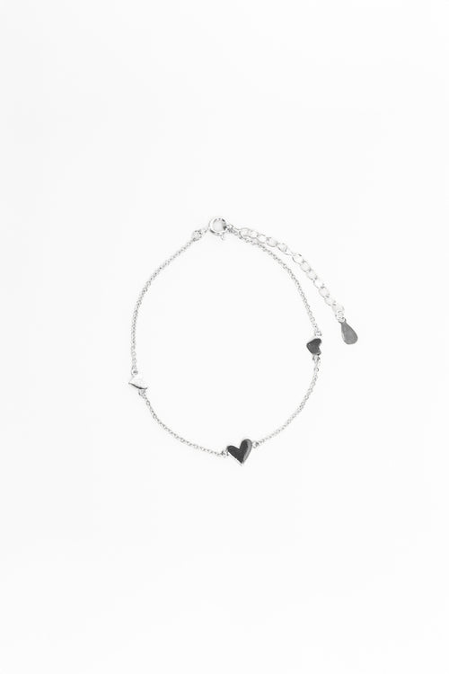 Silver bracelet with heart-shaped charms on a white background