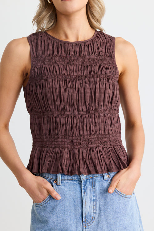 model wears shirred cotton brown top