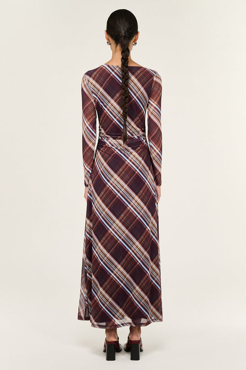 Woman wearing a plaid dress with a white background