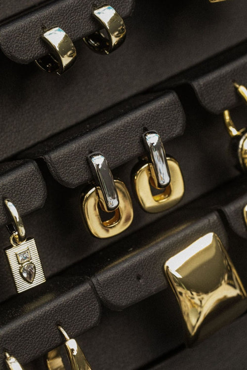 Close-up of U-shaped two tone gold and silver hoop earrings.