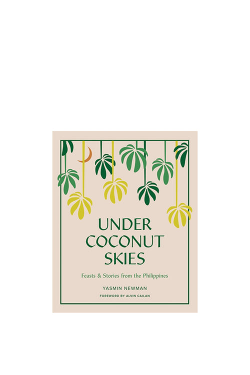 Book cover of 'Under Coconut Skies' with leaf design on a beige background
