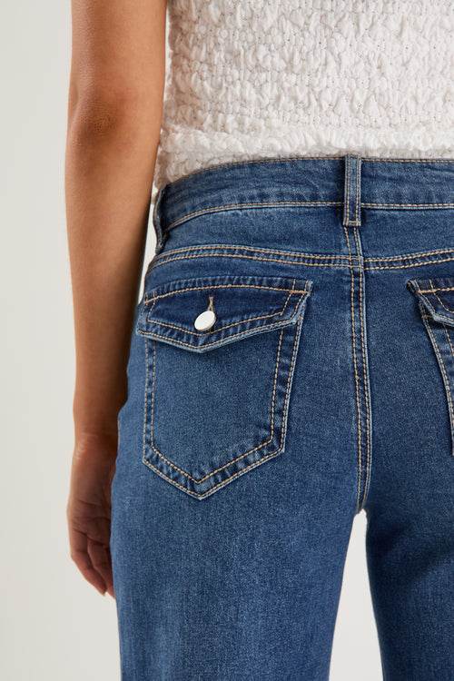 model wears a pair of blue jeans with a white tank top