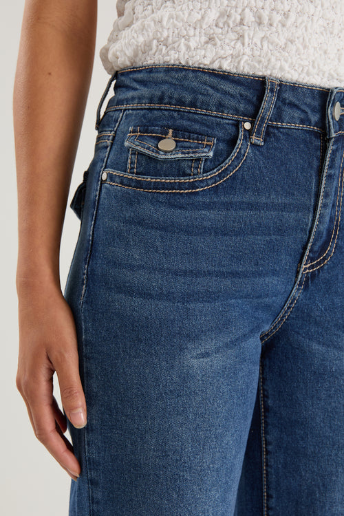 model wears a pair of blue jeans with a white tank top