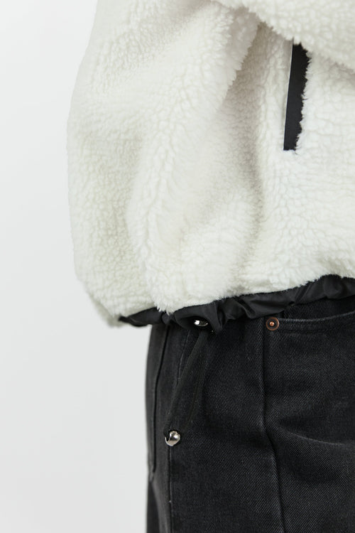This cozy cream fleece jacket features a zip-up front, sporty black side stripes, and a relaxed fit, paired with black wash jeans for a casual yet stylish look.