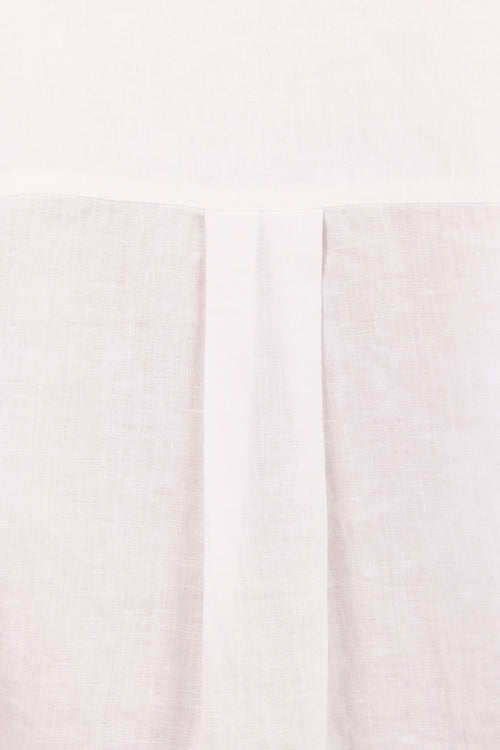 A close-up of a light off-white or cream textured fabric with a central vertical pleat or fold running down the middle.
col_pattern