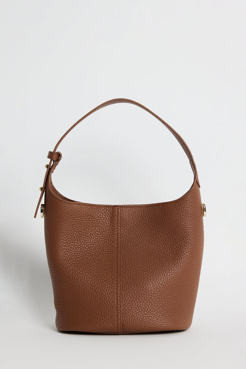 A brown pebbled leather bucket bag with a single shoulder strap and gold-tone hardware, photographed against a clean white background.