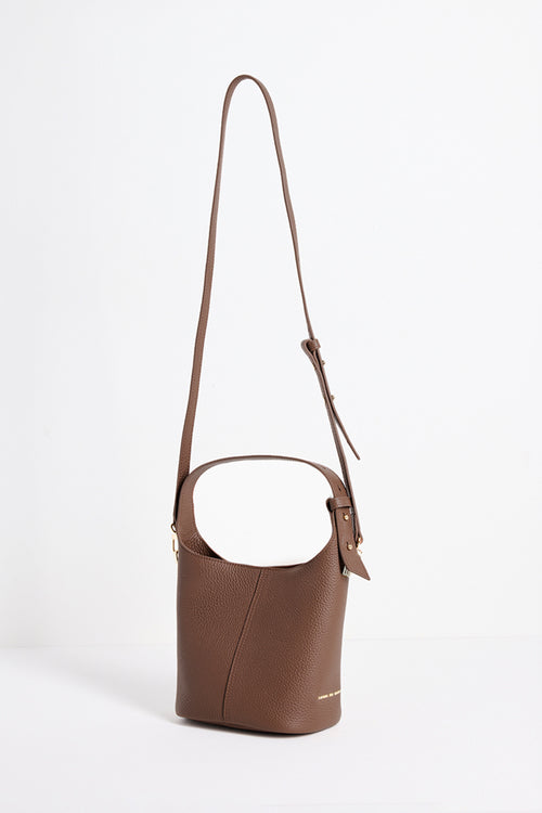 A brown pebbled leather bucket bag with a single shoulder strap, shown on a clean white background.