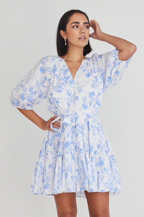 model wears a blue floral mini dress