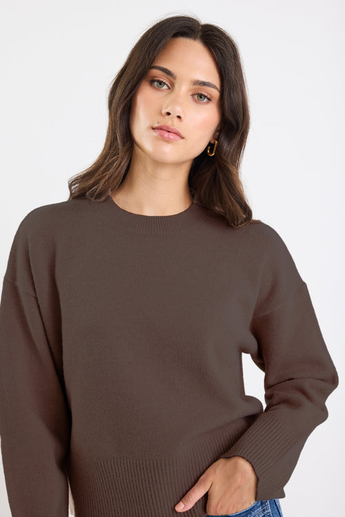 Woman wearing a brown sweater on a white background