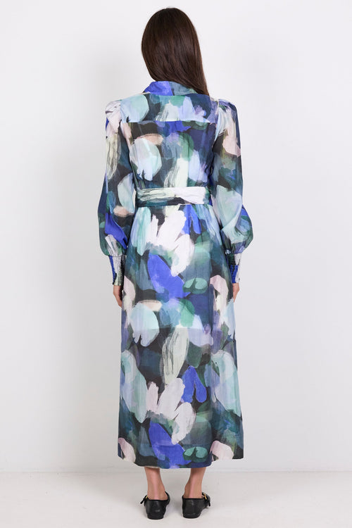 Woman wearing a long print dress with a white background
