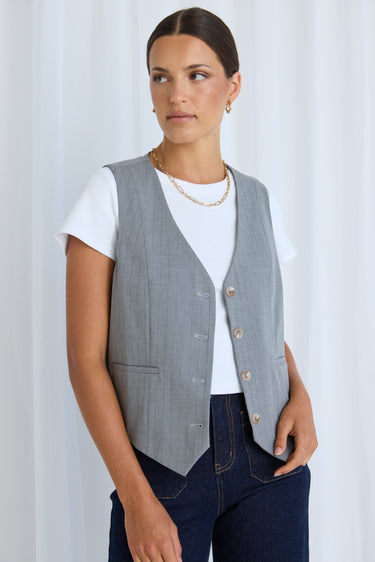 model wears a grey vest with jeans