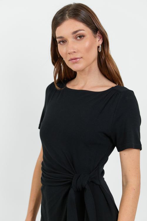 This black dress features a flattering side tie detail and a relaxed fit, perfect for both casual and dressy occasions.