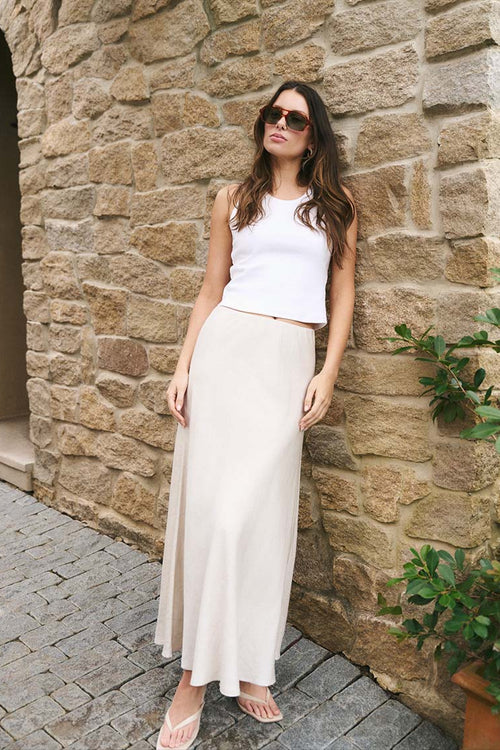 model wearing a beige linen skirt and white top
