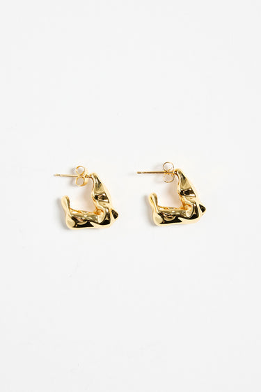 gold-plated brass huggie earrings with a wavy, organic design, photographed flat against a white background.