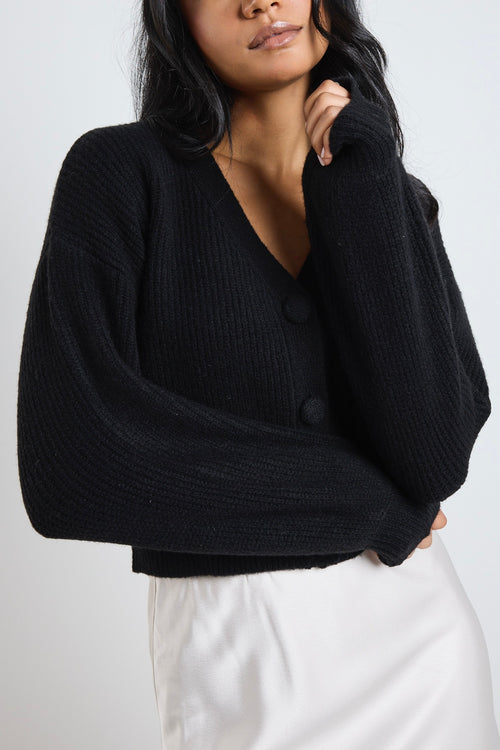 Model wears a black knit cardigan