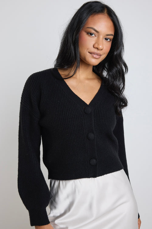 Model wears a black knit cardigan