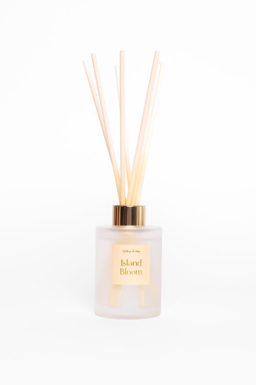 Diffuser with wooden sticks labeled 'Island Bloom' on a white background