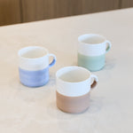 Artist Stone hand painted two tone stackable mug shown alongside blue and sage green colourways for styling reference; listing is for the stone mug only.