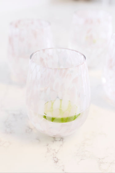 A stemless wine glass with a white and pink marbled pattern. 