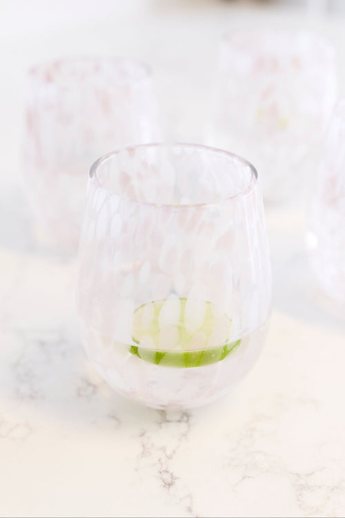 A stemless wine glass with a white and pink marbled pattern. 
