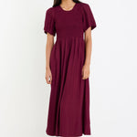 Woman wearing a burgundy dress on a white background