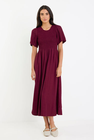 Woman wearing a burgundy dress on a white background