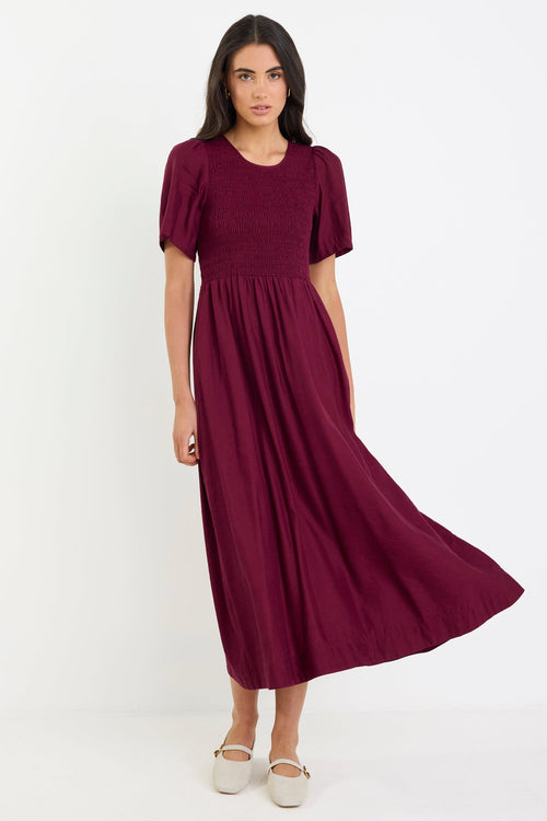 Woman wearing a burgundy dress on a white background