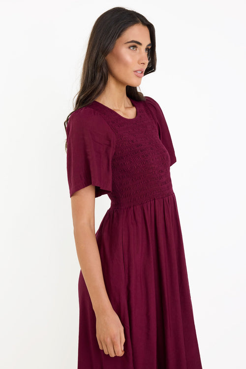 Woman wearing a burgundy dress on a white background
