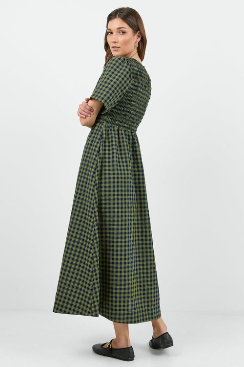 Woman wearing a green checkered dress on a white background