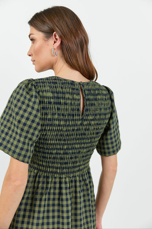 Woman wearing a green and blue checkered dress on a white background