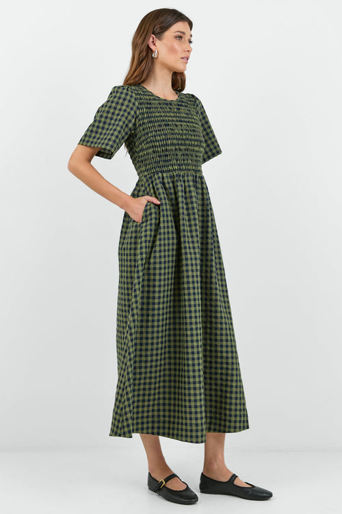 Woman wearing a green checkered dress on a white background