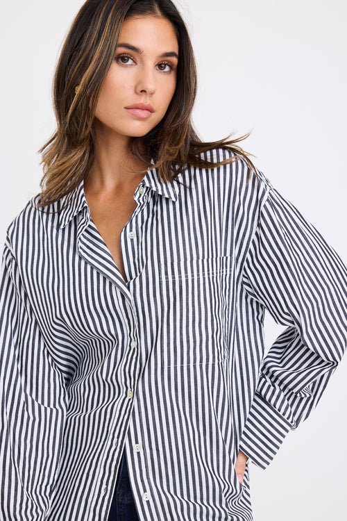 Woman wearing a black and white striped shirt against a white background