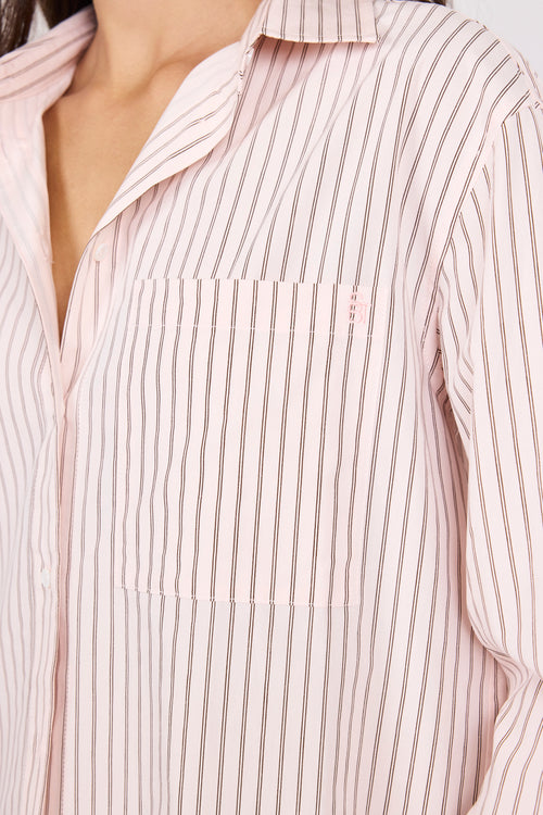 Close-up of a person wearing a light pink and white striped shirt.