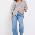 Woman wearing a striped shirt and blue jeans on a white background