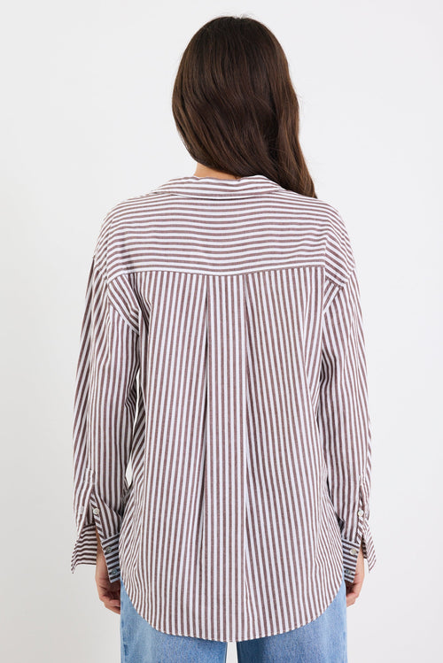 Woman wearing a striped shirt with long sleeves on a white background