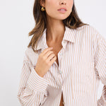 Model wears a stripe white and tan shirt 
