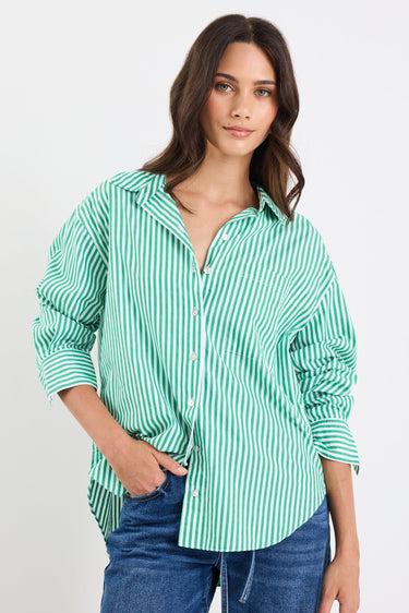 Woman wearing a green and white striped shirt with blue jeans on a white background