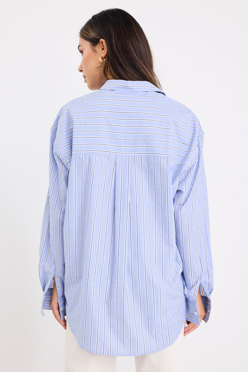 model wears a blue stripe shirt with ecru jeans