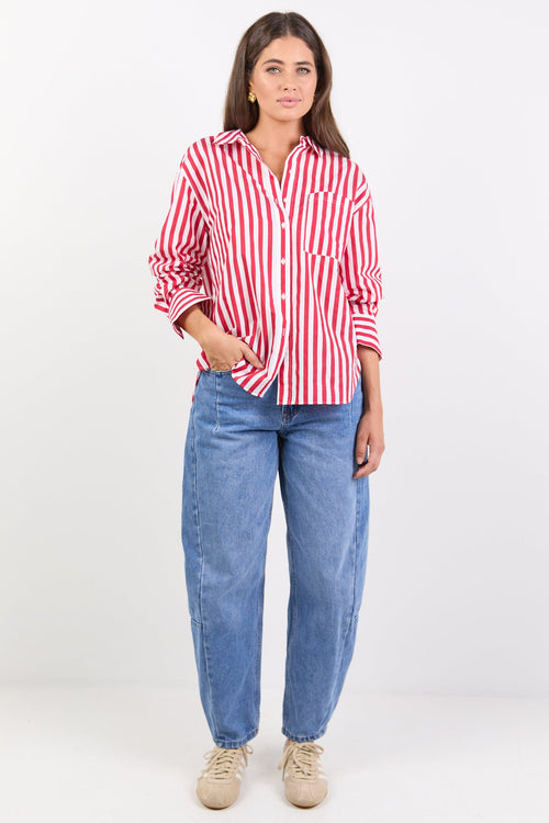 Woman wearing a red and white striped shirt and blue jeans on a white background