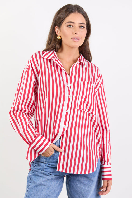 Woman wearing a red and white striped shirt with blue jeans on a white background