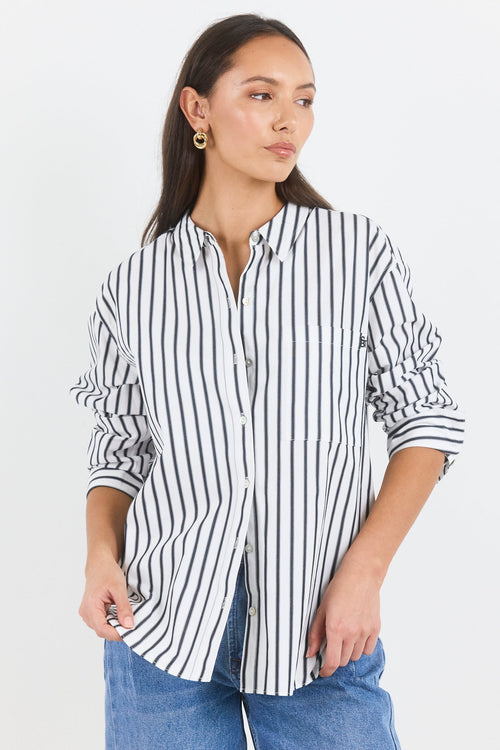 Woman wearing a black and white striped shirt and blue jeans on a white background