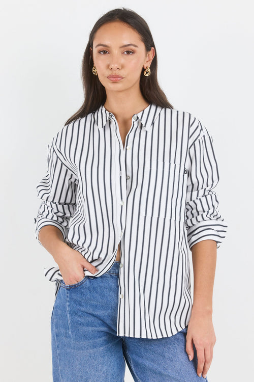 Woman wearing a black and white striped shirt and blue jeans on a white background