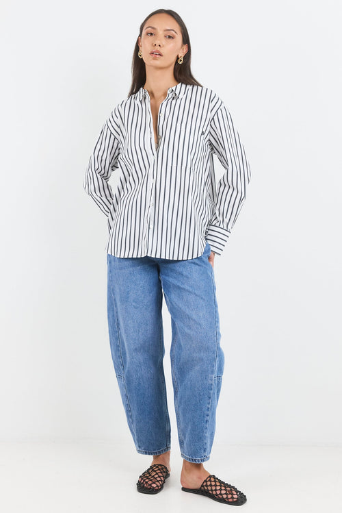 Woman wearing a black and white striped shirt and blue jeans on a white background